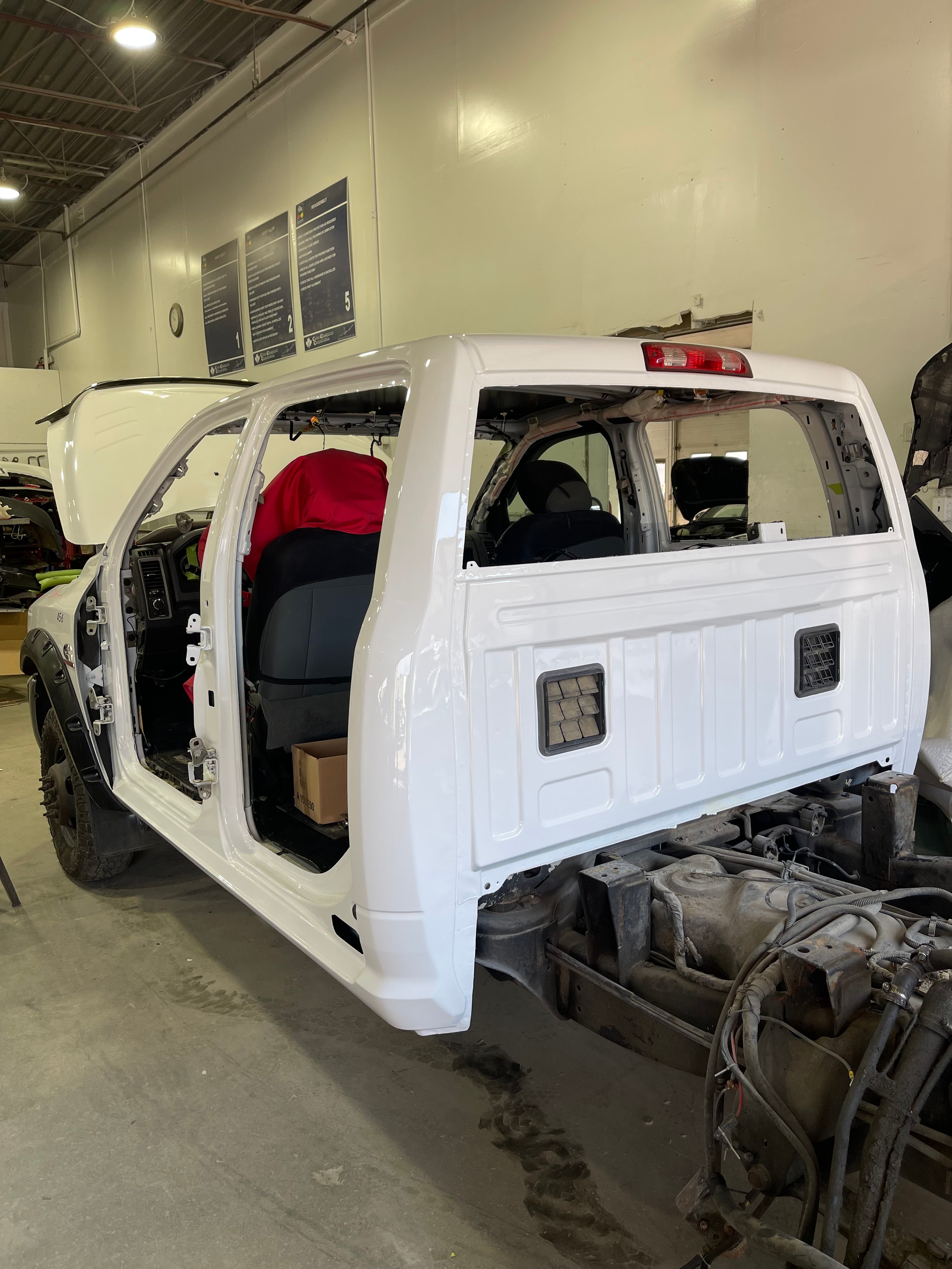Reassembled white vehicle body after collision repair in the MACART workshop